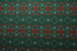 Tkanina świąteczna - czerwone śnieżynki na zielonym tle